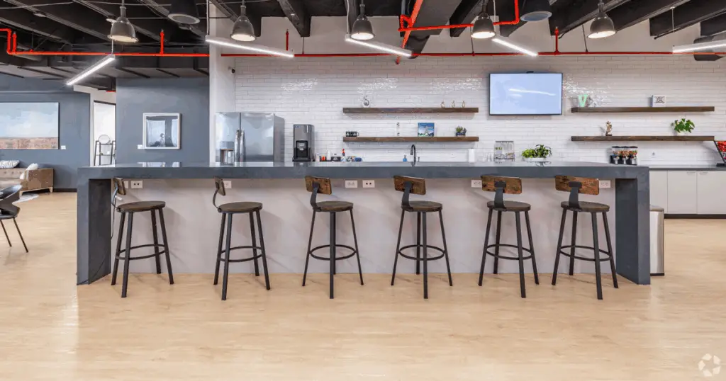 Café-style coworking bar at Strive Coworking Workspaces with high-top seating, modern lighting, and a polished communal workspace.