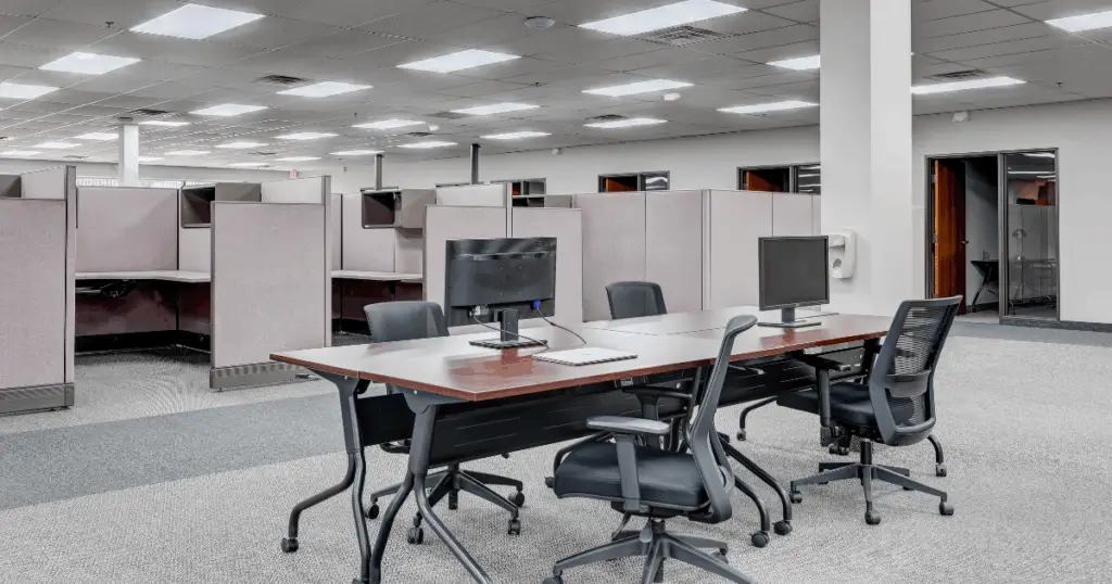 Open coworking workspace at Venture X Braniff Centre in Dallas, Texas, featuring shared desks, ergonomic chairs, and semi-private cubicle seating.