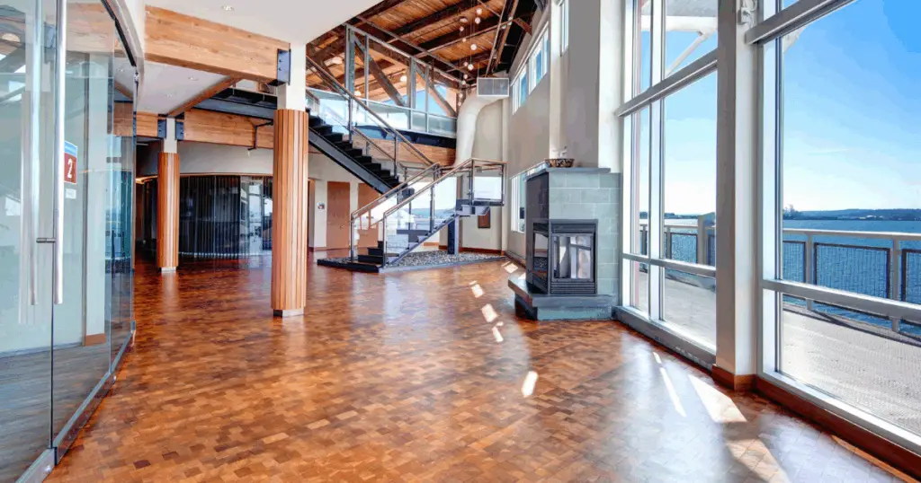 Open event and common area at Strive Coworking Workspaces with expansive windows, modern staircase, and natural light overlooking the water.
