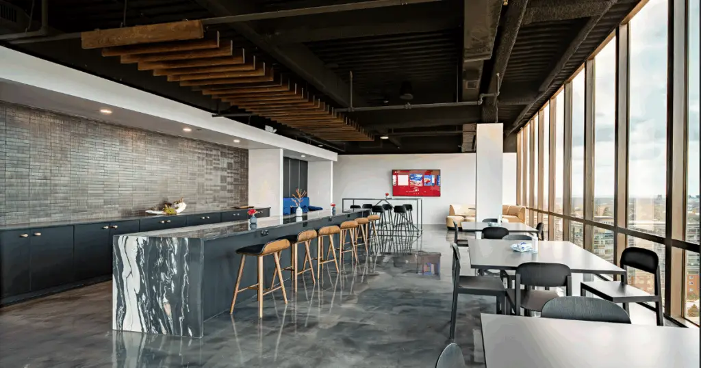 Event space in Dallas at The Gild by Strive Workspaces featuring marble bar, high-top seating, and skyline views.