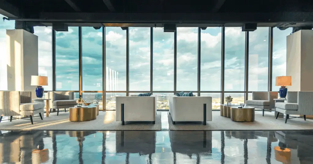 Event space in Dallas at The Gild by Strive Workspaces featuring lounge seating and floor-to-ceiling windows with panoramic skyline views.