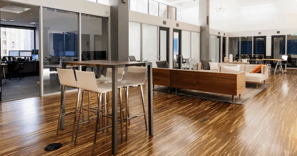 Open hot desk workspace at Strive Coworking Workspaces featuring shared tables, modern lounge seating, and private offices in a bright, professional environment.