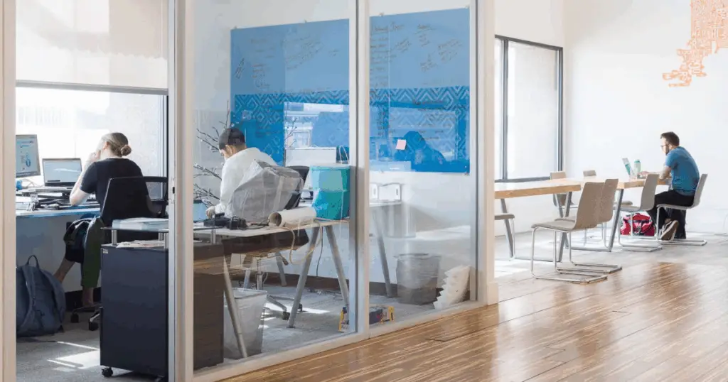 Members working in private offices and shared workspaces at Strive Coworking Workspaces with glass walls and natural light.