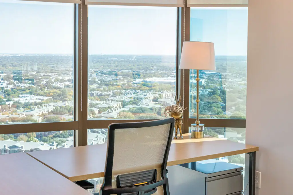Flexible office space at a North Dallas coworking workspace showing desks, meeting rooms, and city views