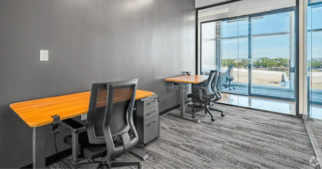 Private office at Strive Coworking Workspaces with multiple workstations, ergonomic seating, storage, and floor-to-ceiling windows.