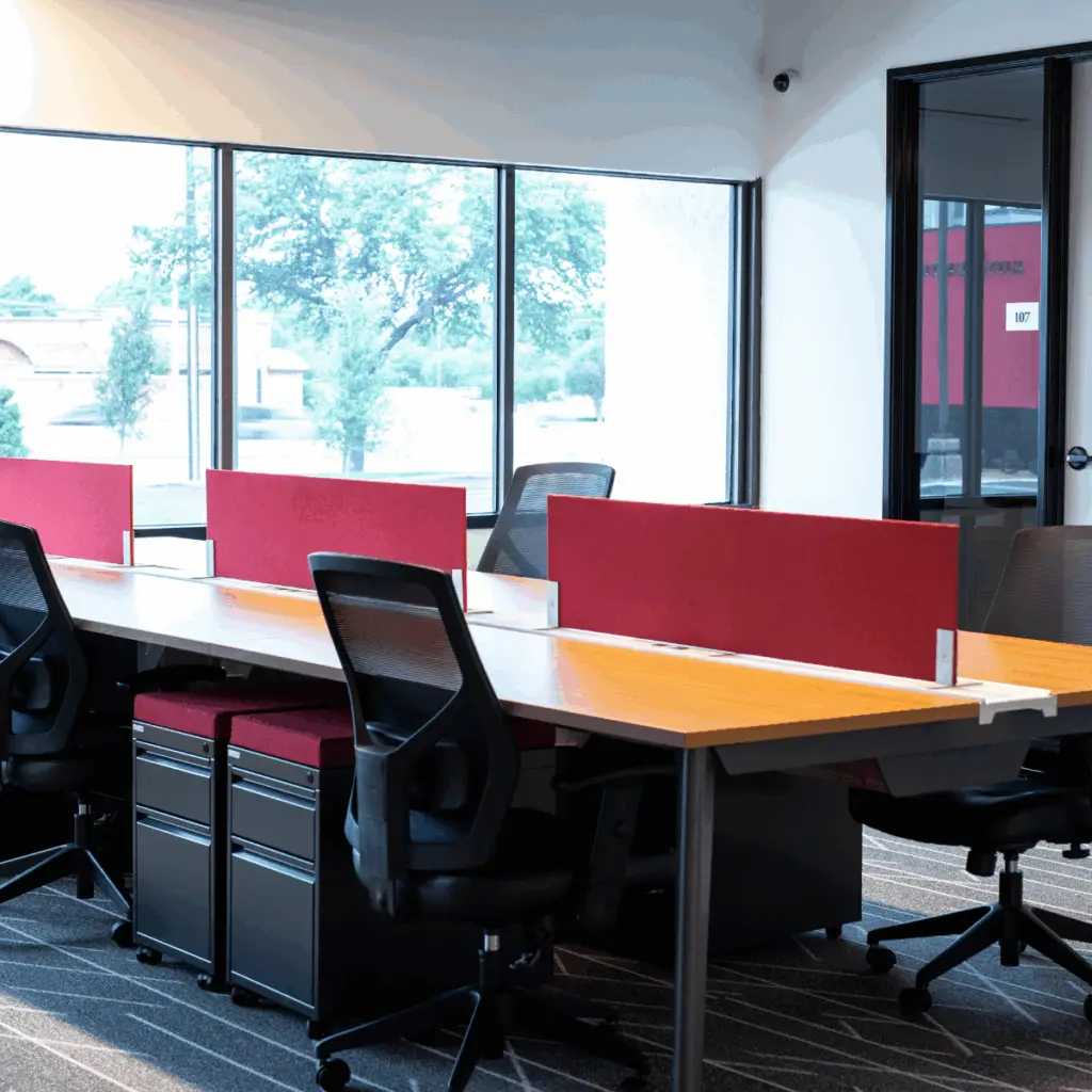 Dedicated desk workspace at Strive Coworking Workspaces with personal desks, privacy panels, storage drawers, and natural light.