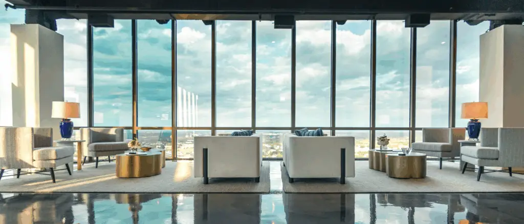 Interior lounge at Flex at The Gild in Dallas, Texas, featuring modern seating, floor-to-ceiling windows, and panoramic city views.