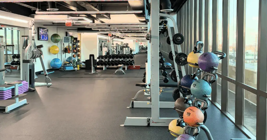 On-site fitness center at Flex at The Gild in Dallas, Texas, featuring strength training equipment, free weights, and medicine balls.
