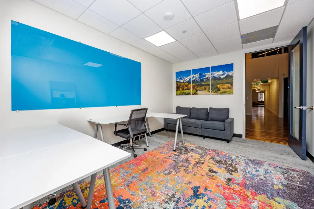 Fully enclosed private office rental in Denver with desk and seating